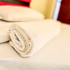 red head board, two sleeping pillows and one rolled up towel