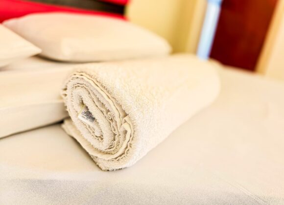 red head board, two sleeping pillows and one rolled up towel